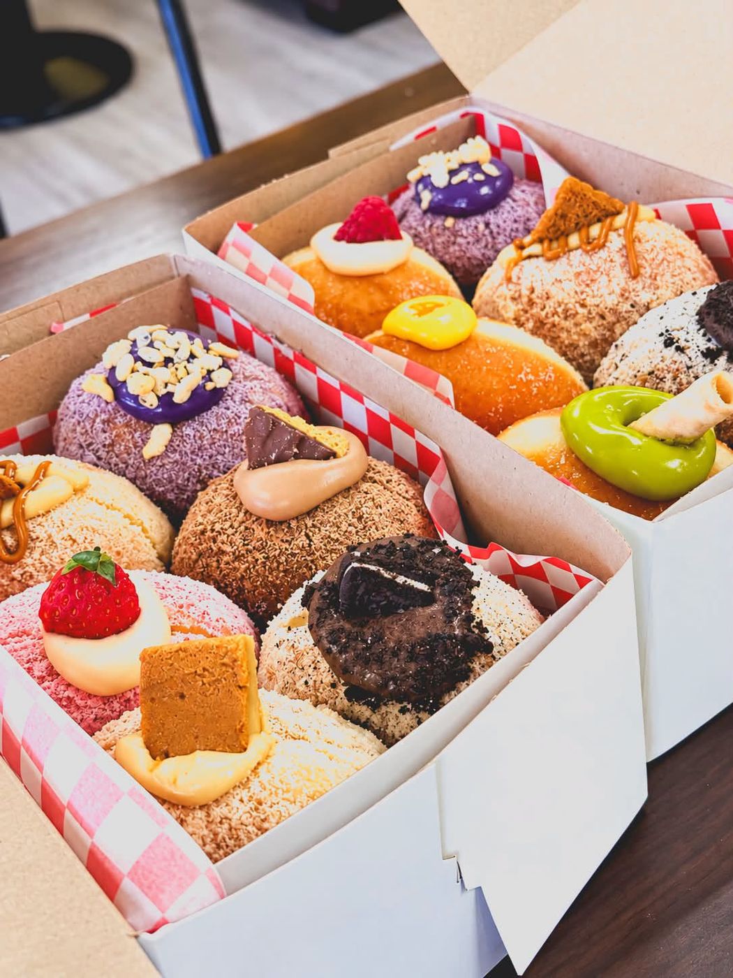 Two Corpuz boxes packed with polvoron, ube and matcha donuts